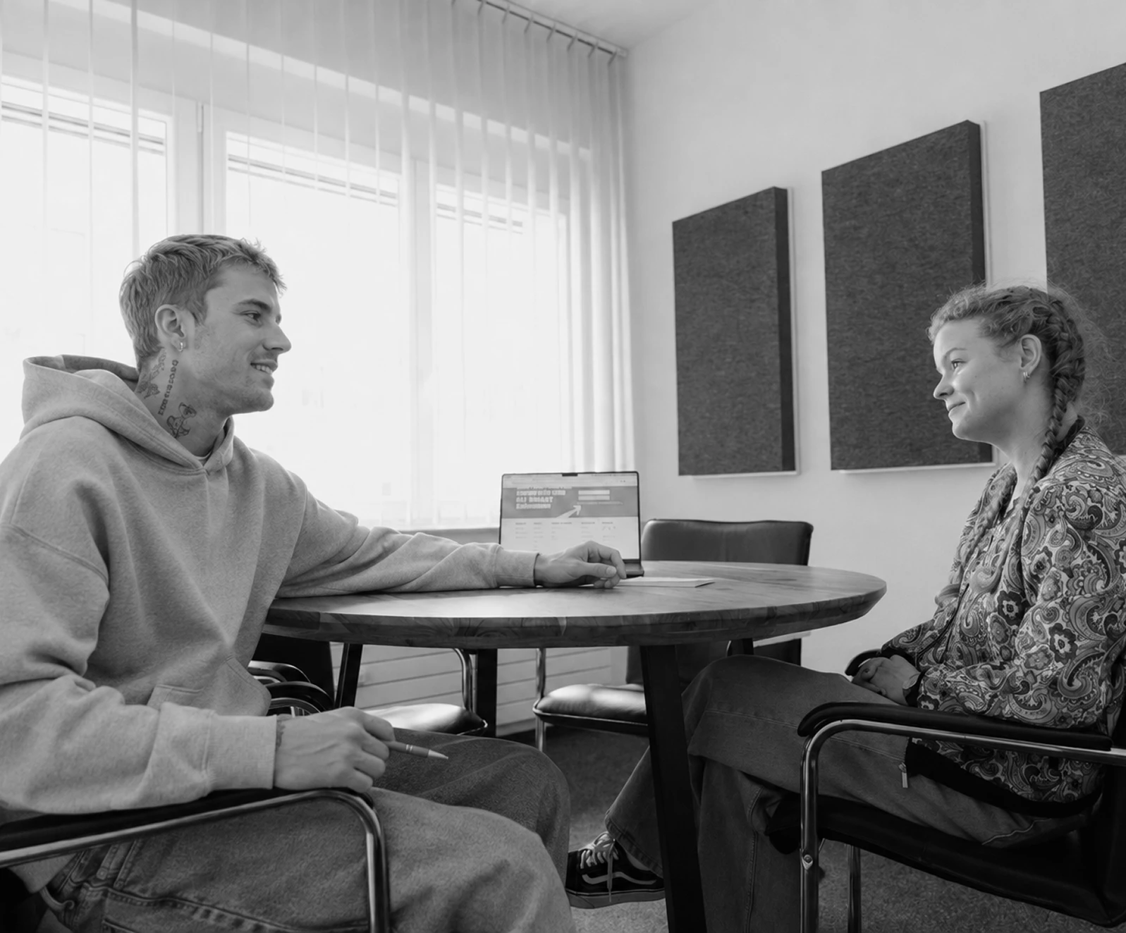 Junge Menschen im Gespräch in einem modernen Büro, ideal für Agentur-Website-Inhalte.